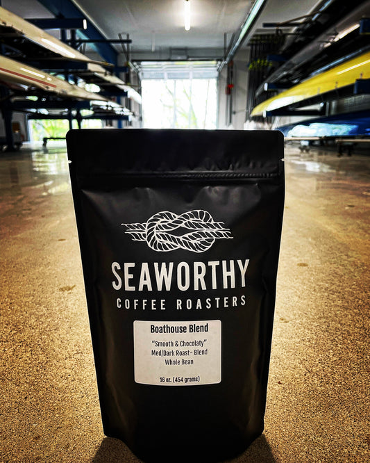 Seaworthy slow roasted, small batch, low acid coffee. 1 pound bag of Boathouse Blend medium dark roast coffee.  Boathouse with rowing shells on racks.