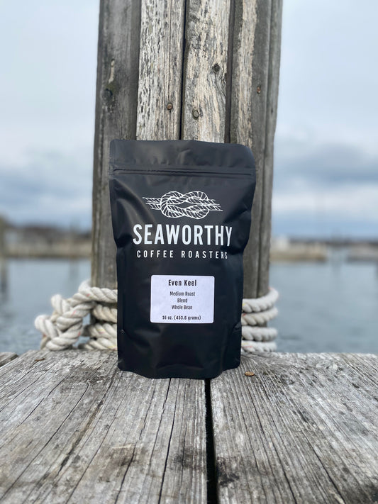 Seaworthy slow roasted, small batch, low acid coffee. 1 pound bag of Even Keel medium roast specialty coffee.  Coffee bag on boat dock with nautical rope.