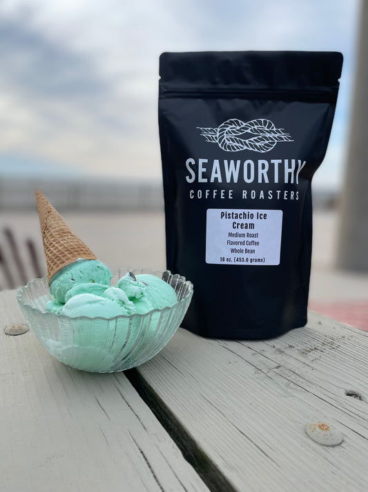 Seaworthy slow roasted, small batch, low acid coffee. 1 pound bag of Pistachio Creme flavored coffee.  Bag of coffee on picnic table.  Bowl of pistachio ice cream.  Ocean in background.