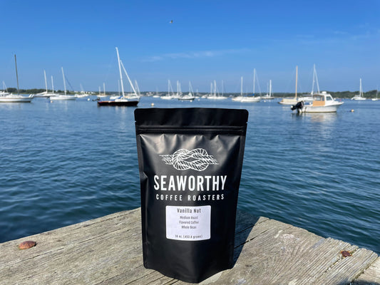 Seaworthy slow roasted, small batch, low acid coffee. 1 pound bag of Vanilla Nut flavored coffee.  Bag of coffee is on dock with sailboats in the background.