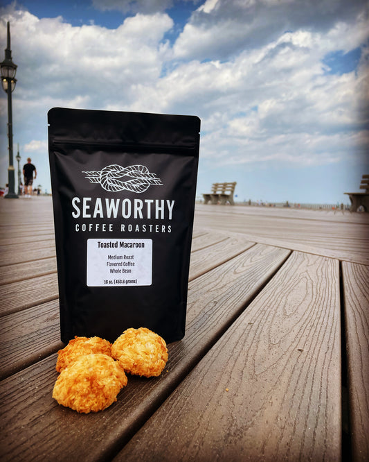 Seaworthy slow roasted, small batch, low acid coffee. 1 pound bag of Toasted Macaroon flavored coffee.  Bag of coffee on Jersey Shore boardwalk with ocean in background.